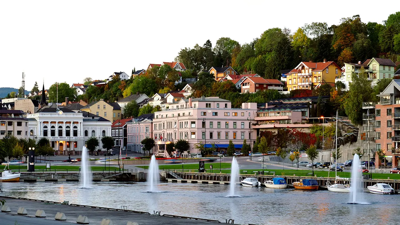 Skien sentrum med mange bygninger og fontener i vannet.