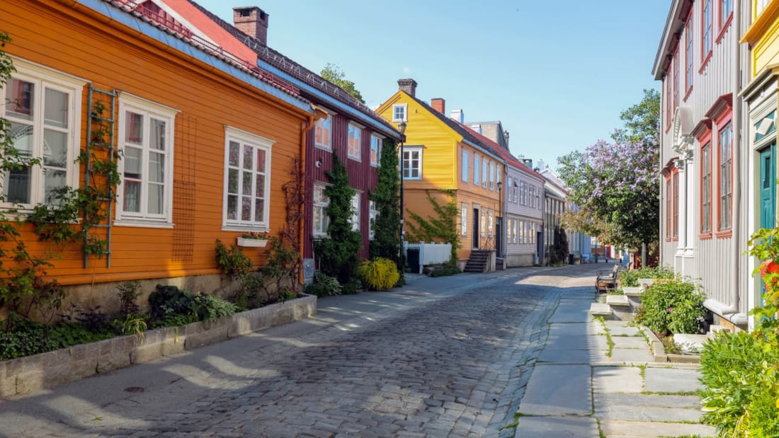 Bakklandet i Trondheim består av gågate i brostein og fargerike bygninger.