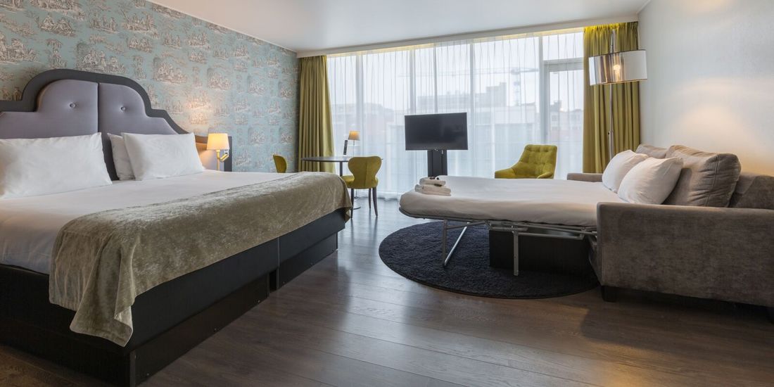 Hotellseng med kaffekopp på nattbordet