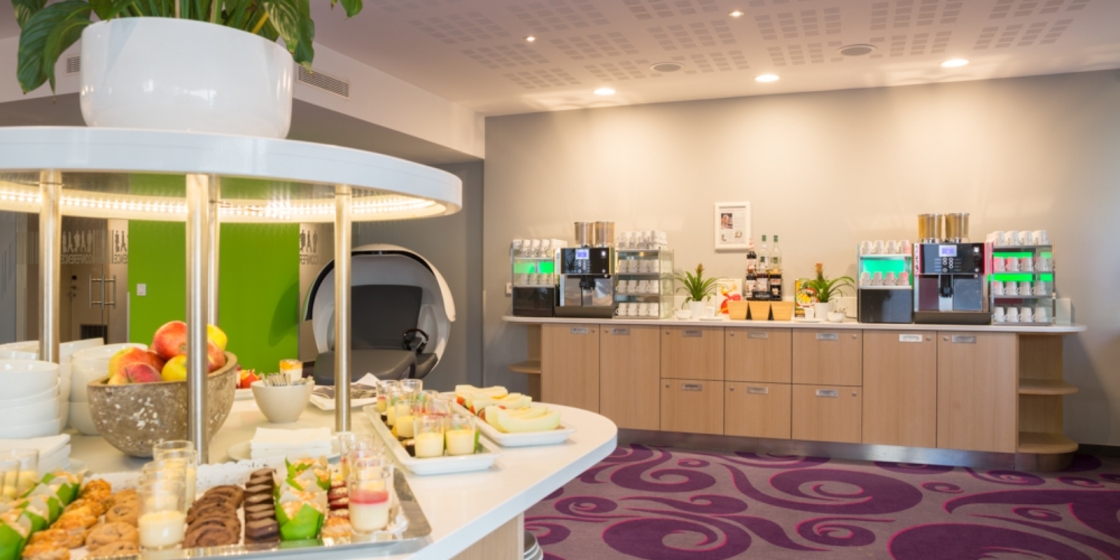 Fargerikt pauseområde med kaffe, frukt og bakevarer.