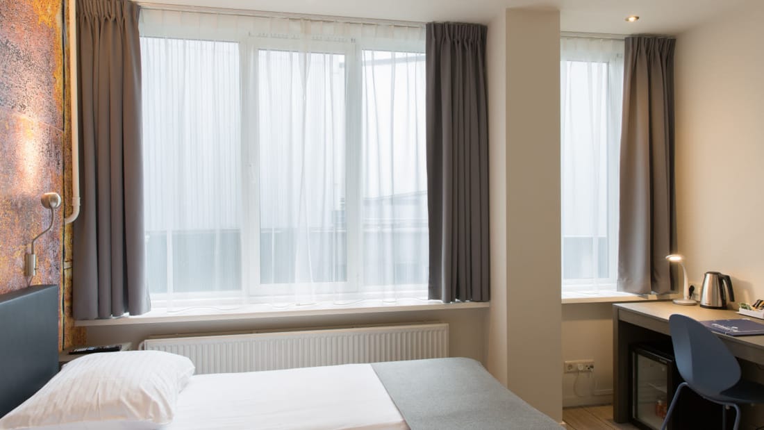 Business rom med stor vindu, dobbelt seng og skrivebord på Thon Hotel Rotterdam