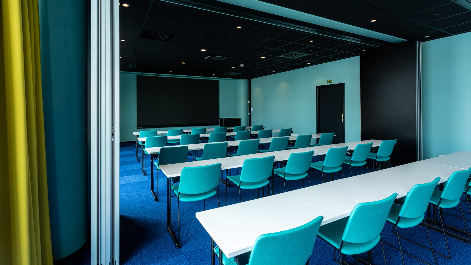 Konferanserom i klasseromoppsett med tv-skjerm