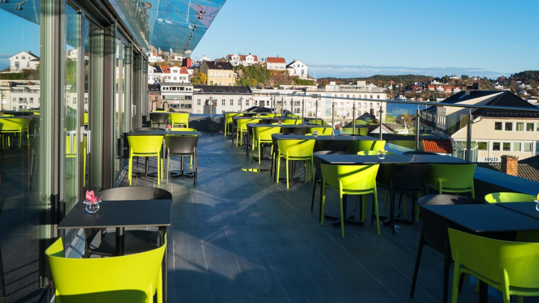 Takterasse hos Thon Hotel Arendal med utsikt til by og hav og med et stort antall sitteplasser 