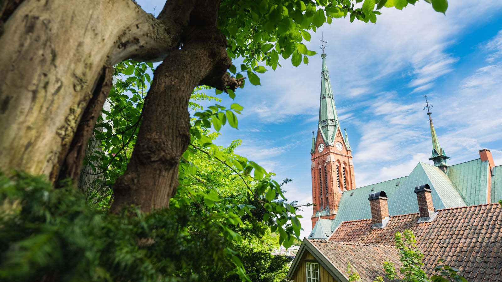 Trefoldighetskirken med spir og trær i bakgrunnen.