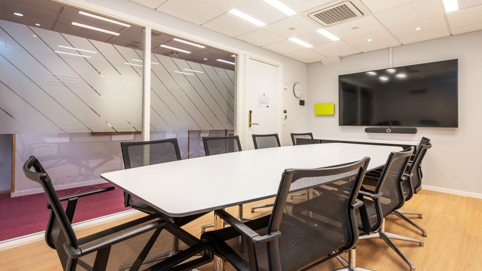 Møterom Skansemyren i styrebord-oppsett, glassvegg mot korridor.