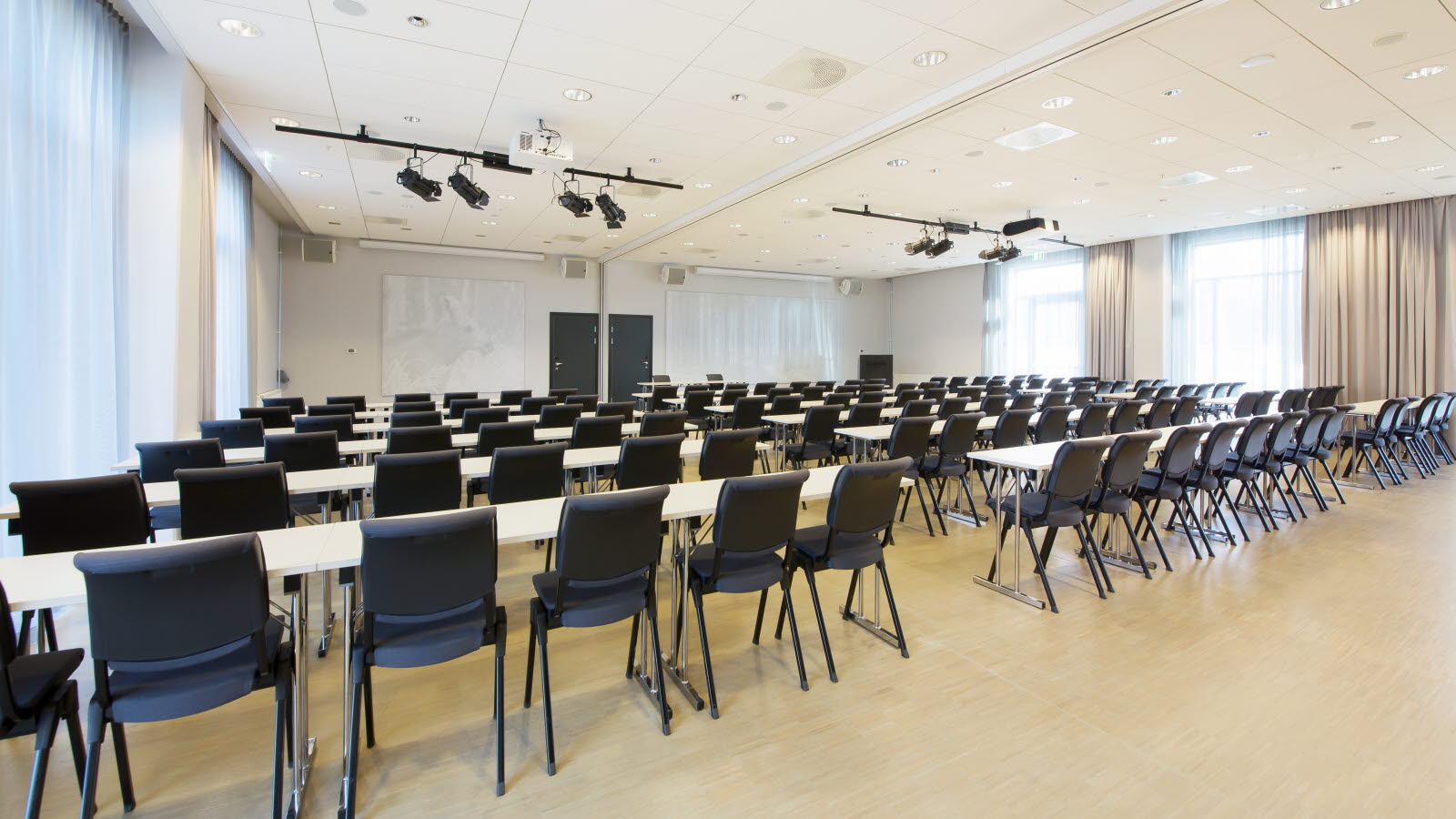 Møterom i klasseromroppsett med projektor, whiteboard og spotlights