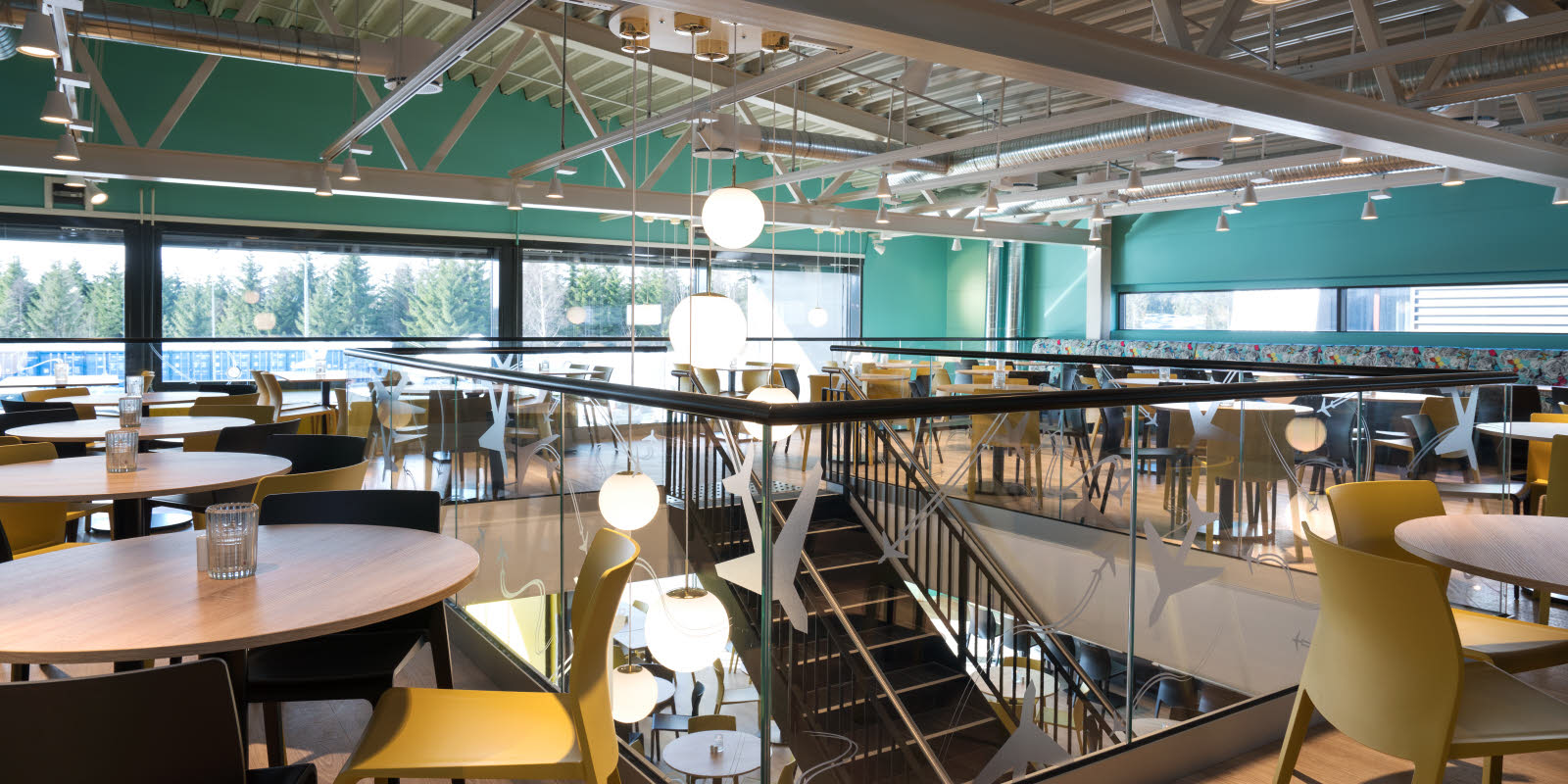 Messanin med runde ståbord, høyt under taket og barstoler på Thon Hotel Gardermoen