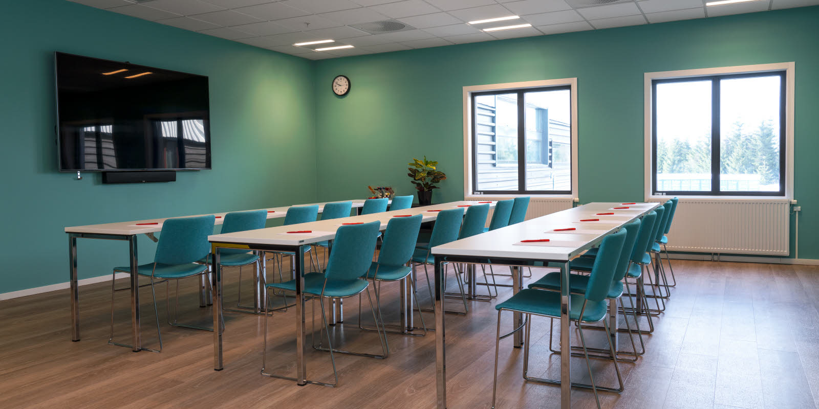 Møterom satt opp i hestesko med turkise vegger og stoler på Thon Hotel Gardermoen