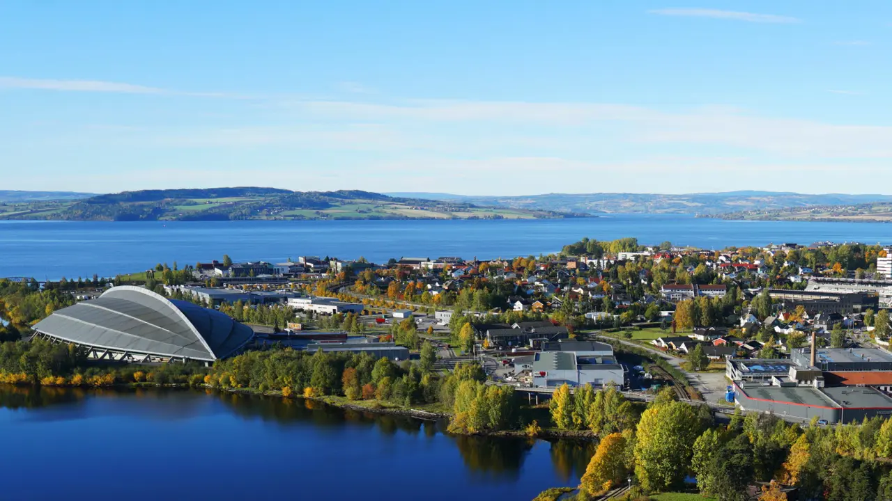 Oversiktsbilde over Hamar. Vikingskipet til venstre. I bakgrunnen ses Mjøsa og fjell.