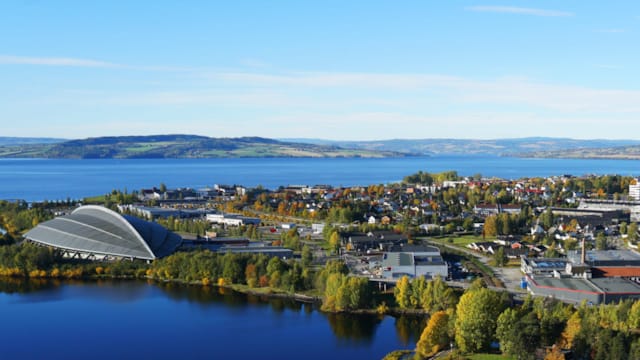 Dronebilde av Hamar. Til venstre ses Vikingskipet og Mjøsa. Til høyre ses sentrum.