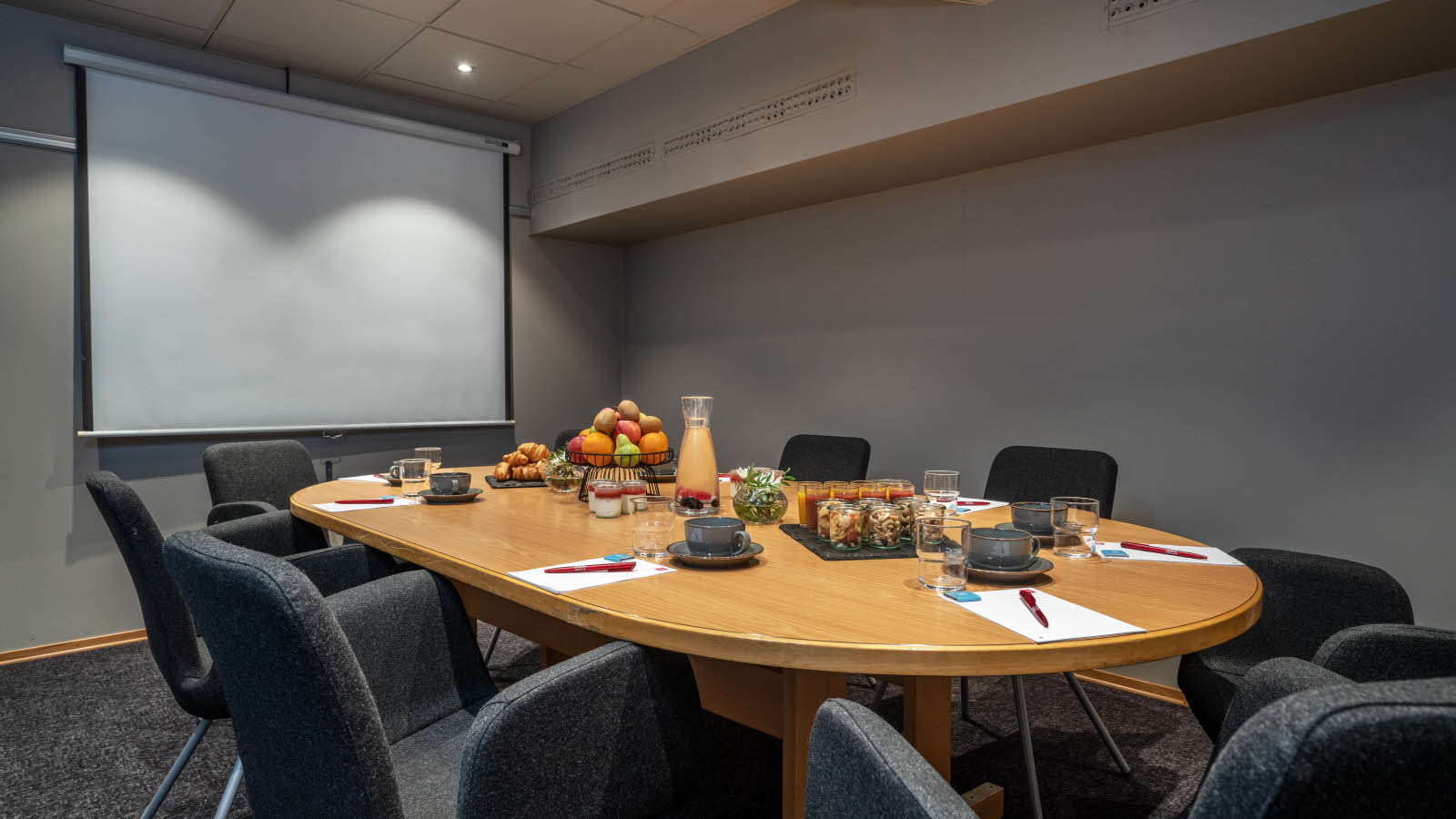 Penn, papir og drops på skrivebord i møtelokale