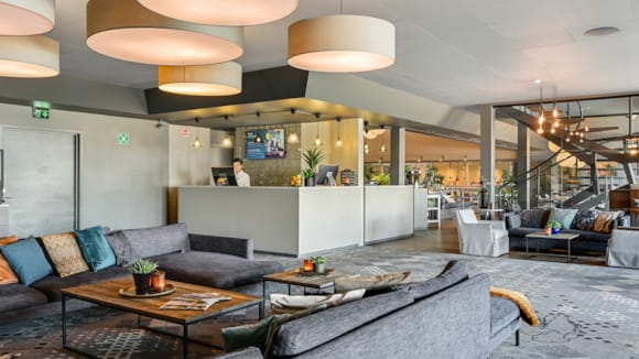 Lounge med bord og sitteplasser på Hotel Horten