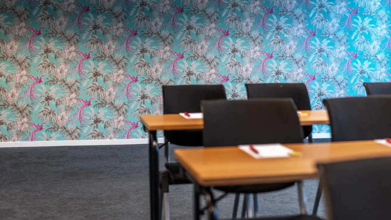 Konferanserom i klasseromsoppsett, mønstrete tapet og teppebelagt gulv hos Thon Partner Hotel Kristiansand.