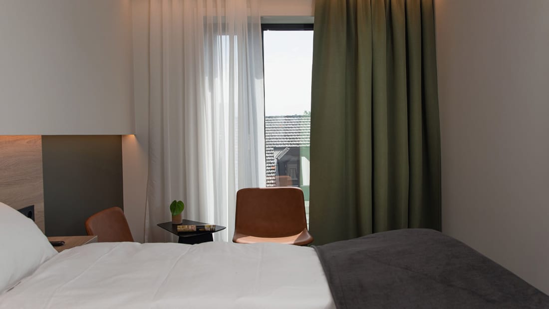 Dobbetlseng og stol i dobbeltrom på Hotel Norge