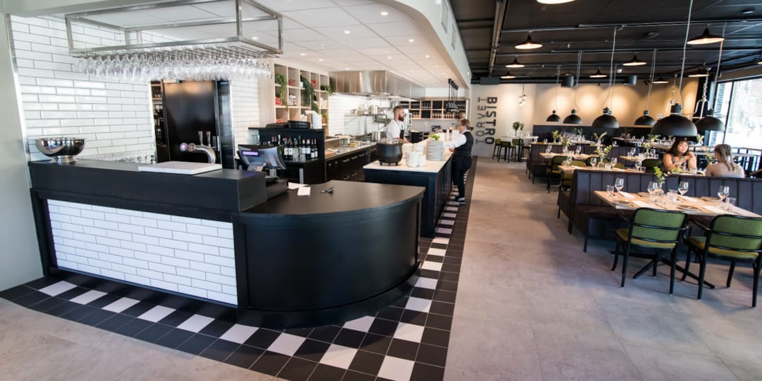 Oversikt over restauranten Restaurant med kokk og servitør som planlegger dagen på Torvet Bistro på Hotel Parken i Kristiansand sentrum