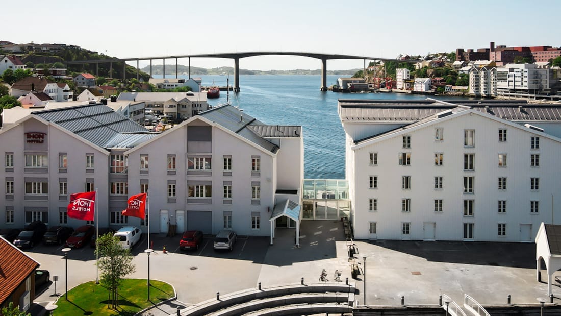 Fasaden til Thon Hotel Kristiansund med Kristiansund by i bakgrunn, sett ovenfra.