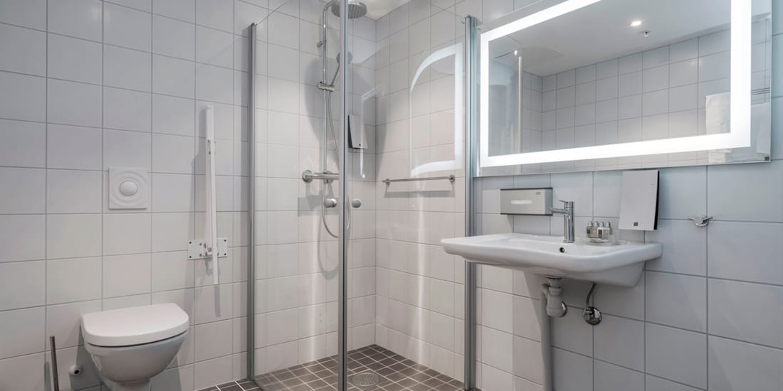 Bad med veggfestet håndtak ved toalett på Thon Hotel Lofoten i Svolvær