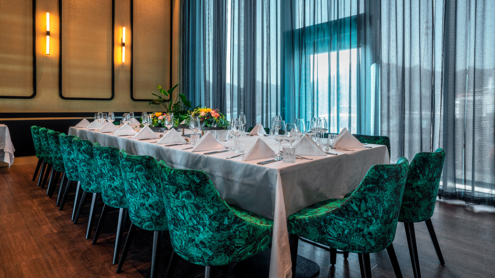 Dekket styrebord med hvit duk og grønne stoler