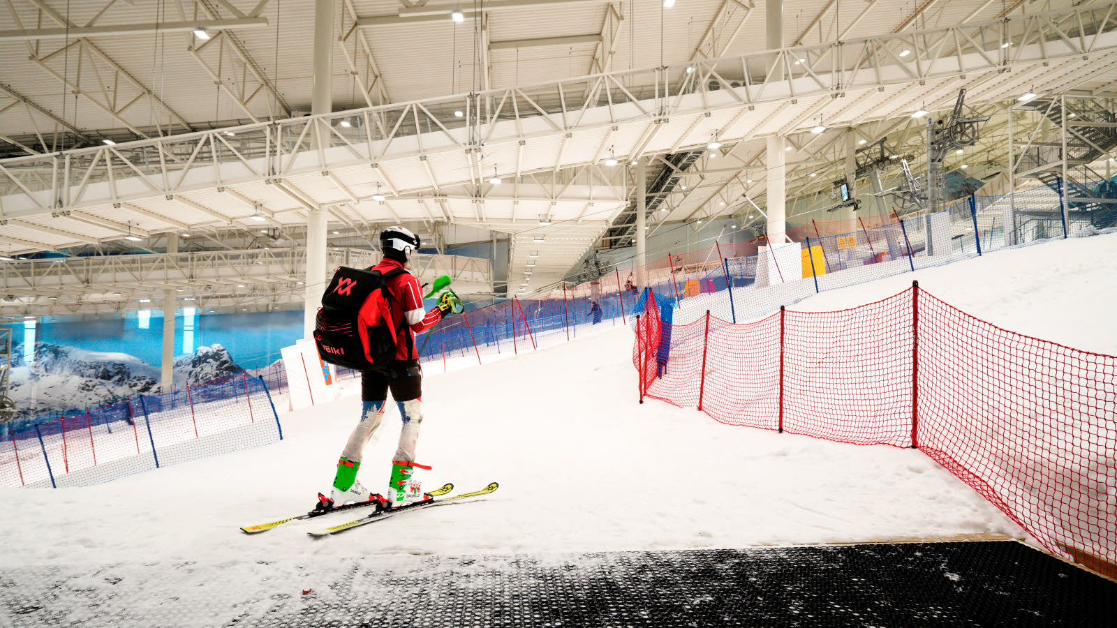 En person i fult slalomutstyr står i skibakken hos SNØ arena.