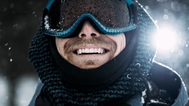 Mann med skibriller smiler bredt