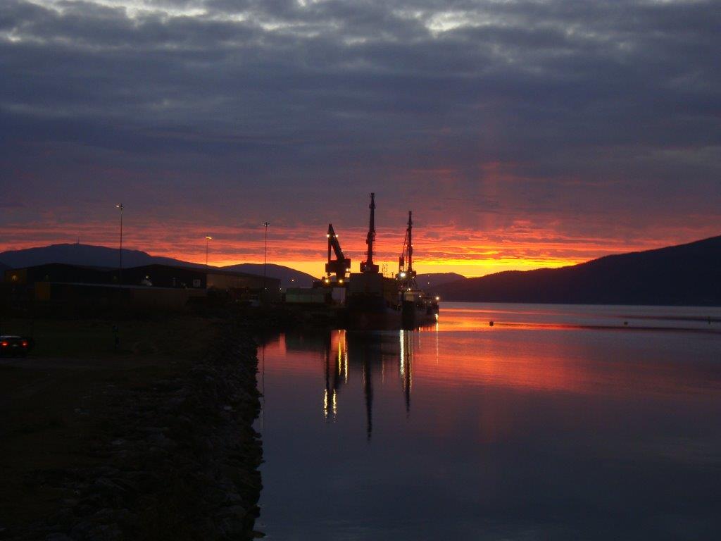 Solnedgang som speiler seg i vannet i Mo i Rana. 