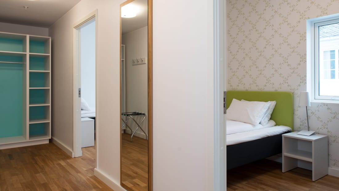 Treroms leilighet med gang, speil, klesskap, og rom med seng på Thon Hotel Sandven i Nordheimsund