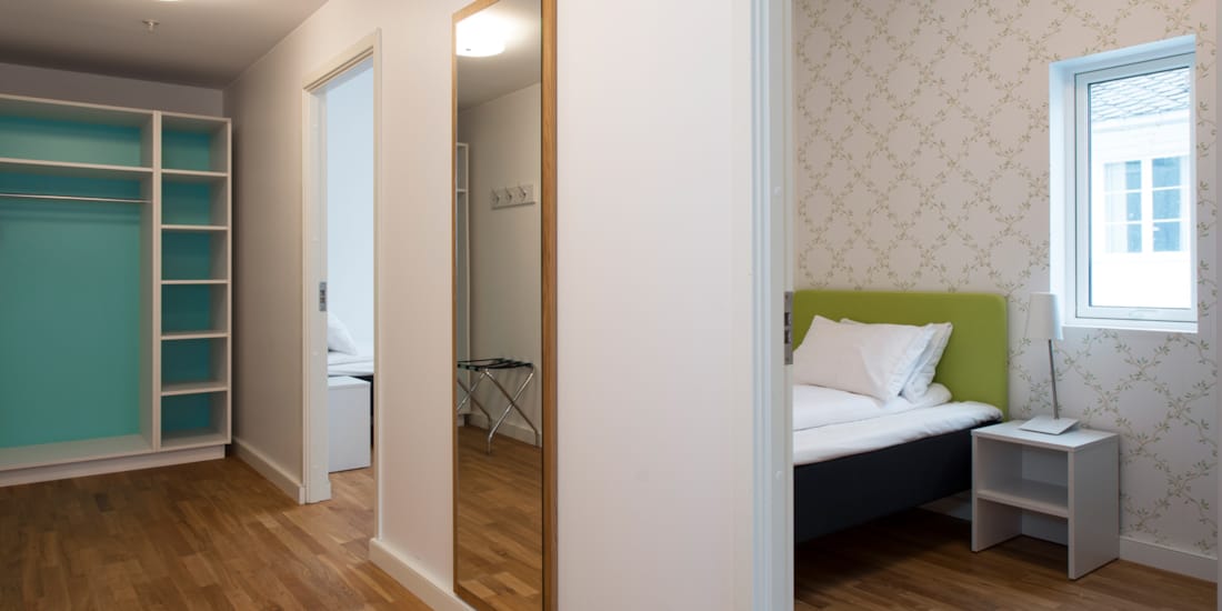 Treroms leilighet med gang, speil, klesskap, og rom med seng på Thon Hotel Sandven i Nordheimsund