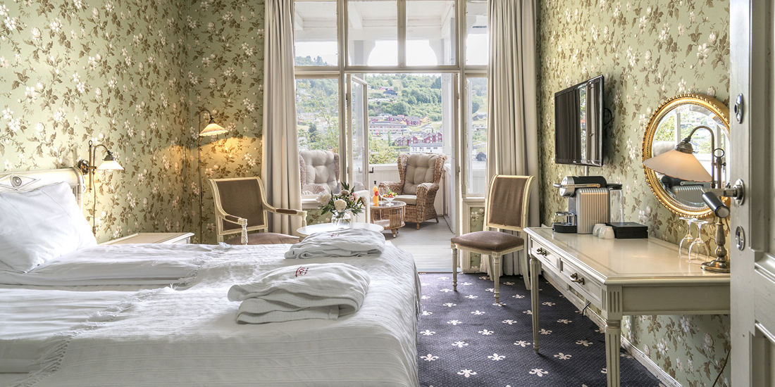 Seng med utsikt mot balkong i superior deluxe rom på Thon Hotel Sandven