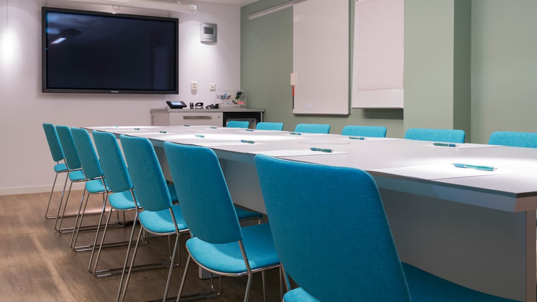 Møtesenter møterom med flatskjerm, projector, lerret og whiteboard