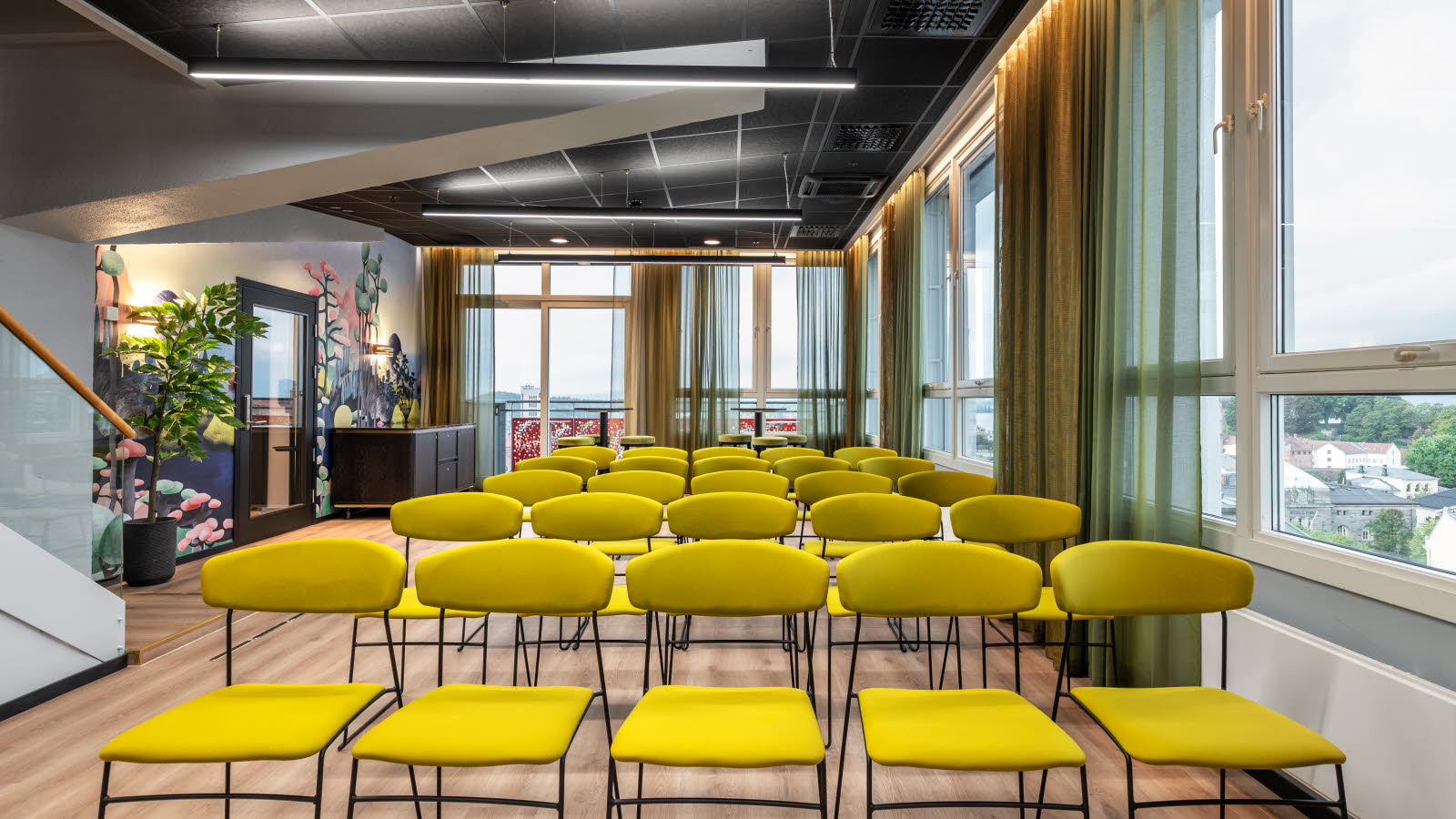 Møterom med oppsett av grønne stoler