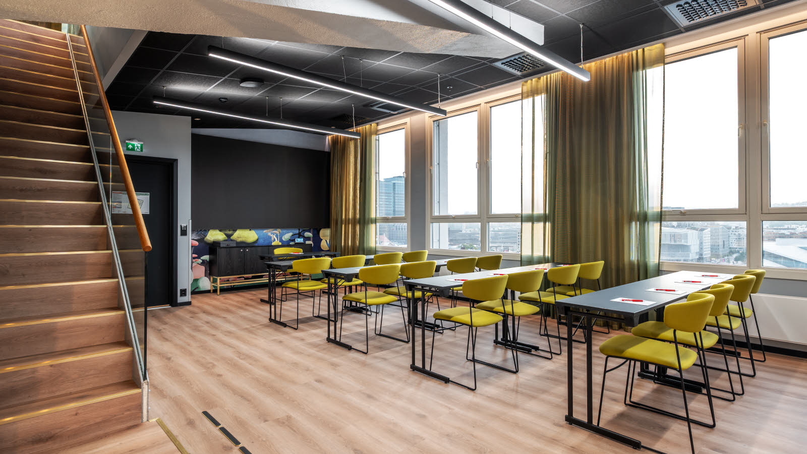 Møterom med klasseromoppsett i en suite med utsikt over Oslo by.