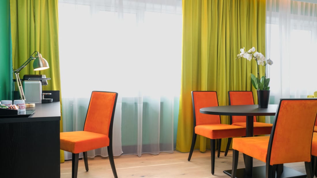 Skrivepult og salongbord med orange stoler på suite på Thon Hotel Europa i Oslo sentrum rett ved Slottsparken
