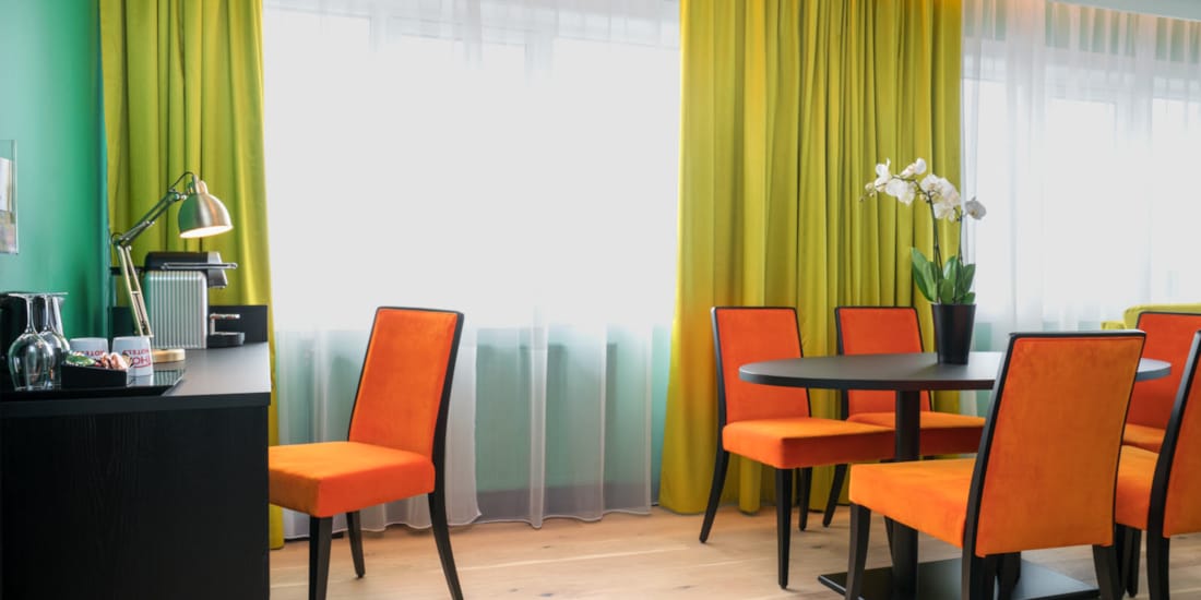 Skrivepult og salongbord med orange stoler på suite på Thon Hotel Europa i Oslo sentrum rett ved Slottsparken