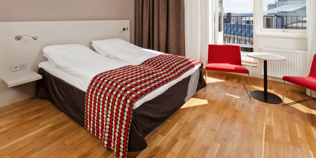 Seng og balkong på superior rom på Thon Hotel Munch i Oslo
