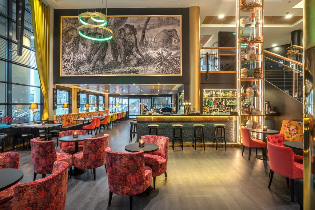 Eufemia bar med rosa mønstrete stoler og et stort maleri