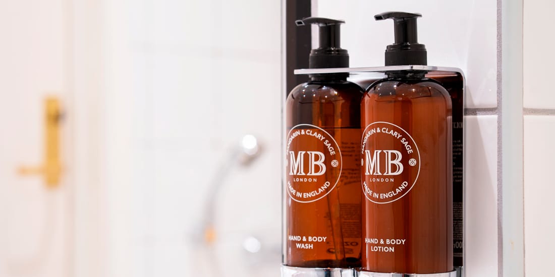 Pumpeflasker med såpe og shampo på bad i oppgadert rom