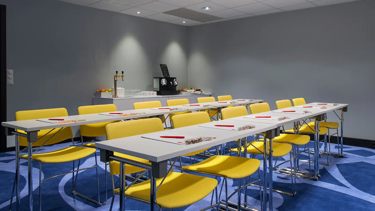 konferanse møterom 2 langbord, 8 plasser, notatblokker, snacks og kaffe i bakgrunn