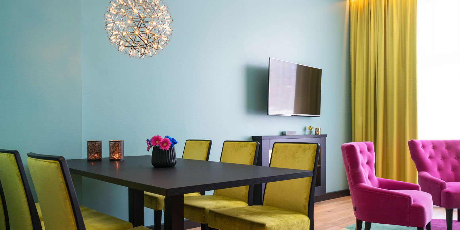 junior suite spisestue, lenestoler, vegghengt tv, friske interiørfarger