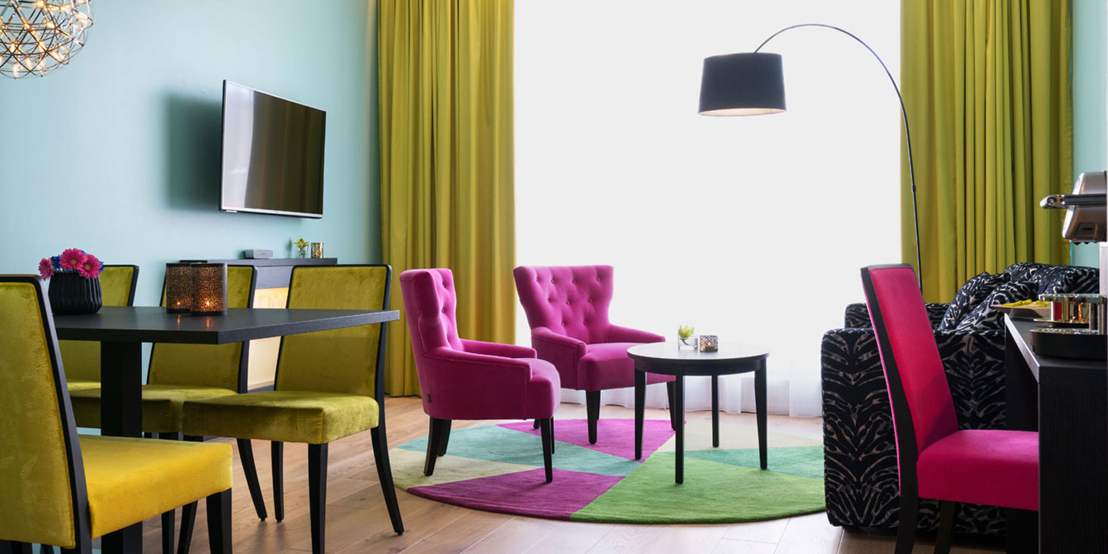 junior suite spisestue, sofagruppe, vegghengt tv, skrivebord, buet stålampe