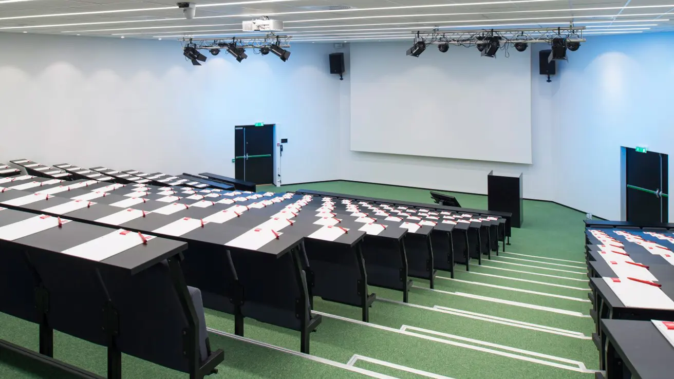 konferansesal atrium, opphøyde stol- og bordrekker med trapp, stort lerret i front