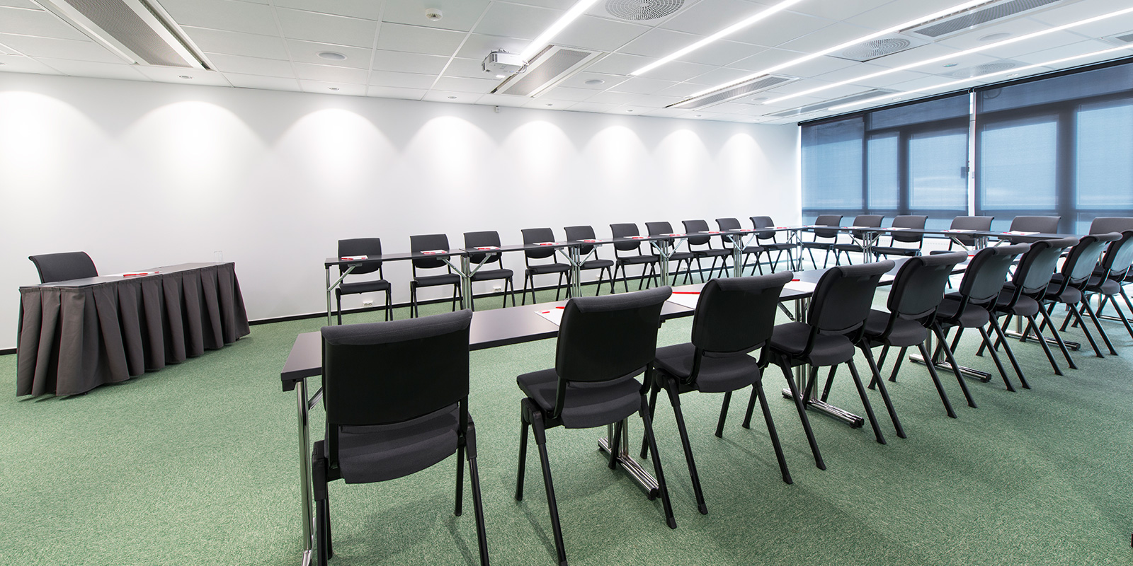 konferanserom bjørvika, u-oppsett av stoler og bord, lederplass i front, 25 plasser, vegg til vegg-teppe