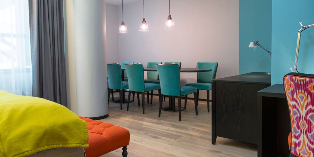 spisetueseksjon på rommet med spisebord og 7 stoler, kontrastfylte farger