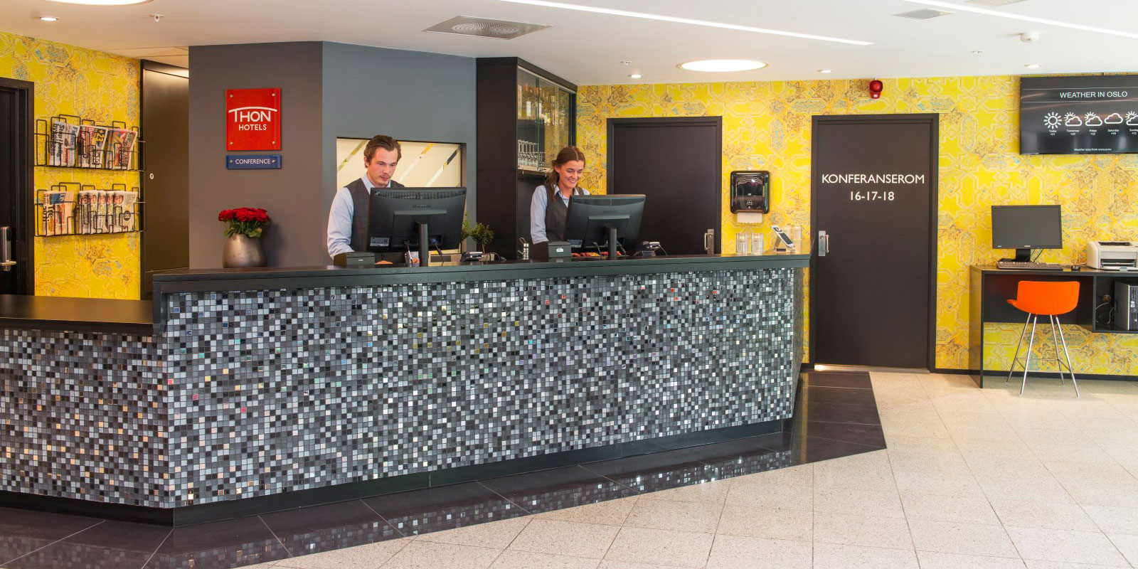 resepsjonsdisk, to resepsjonister på jobb bak disk, inngang til konferanserom