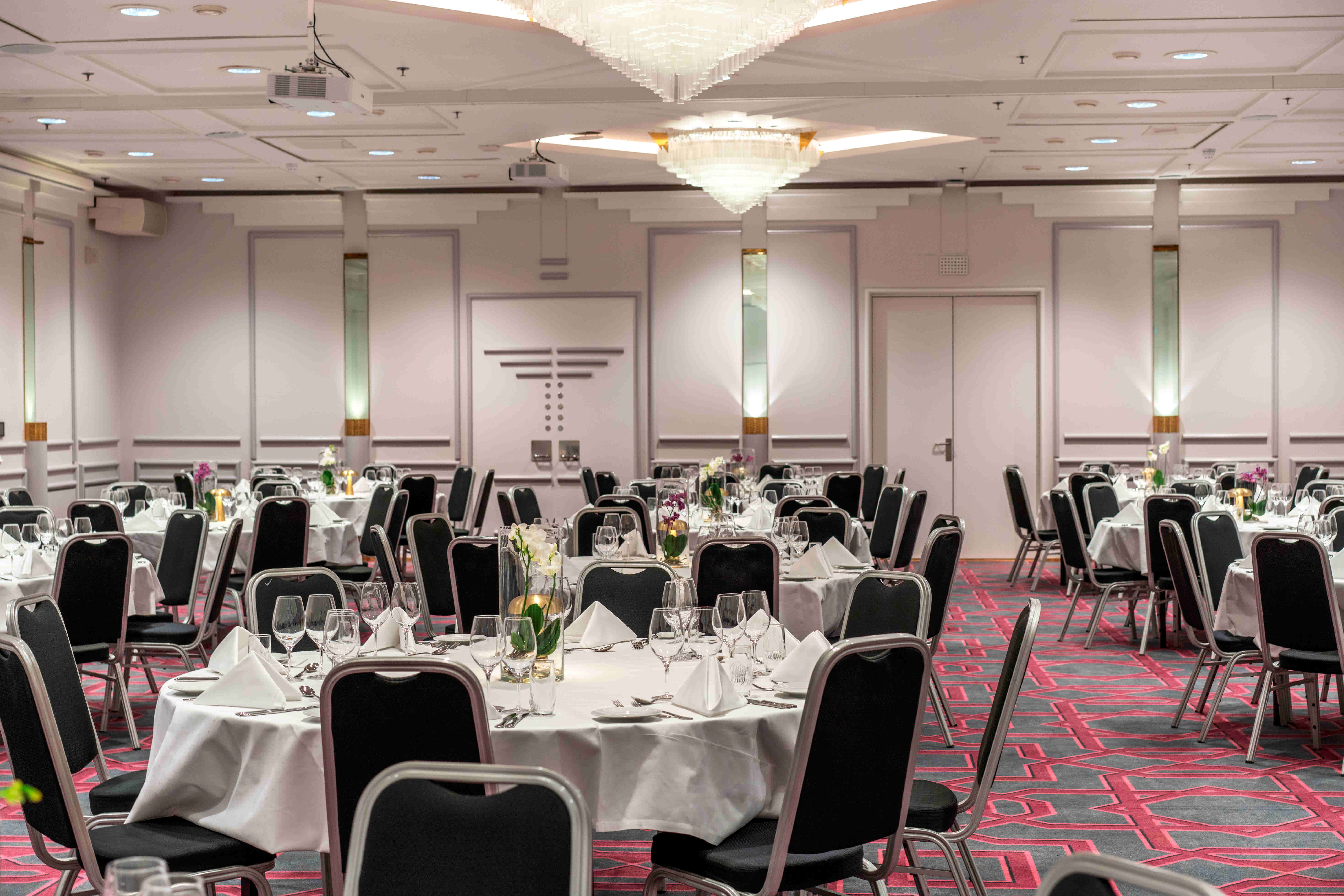 Stort lokal i bankett oppsett med belysning på veggene til arrangementer