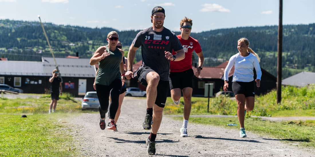 En gjeng deltakere løper med høye kneløft
