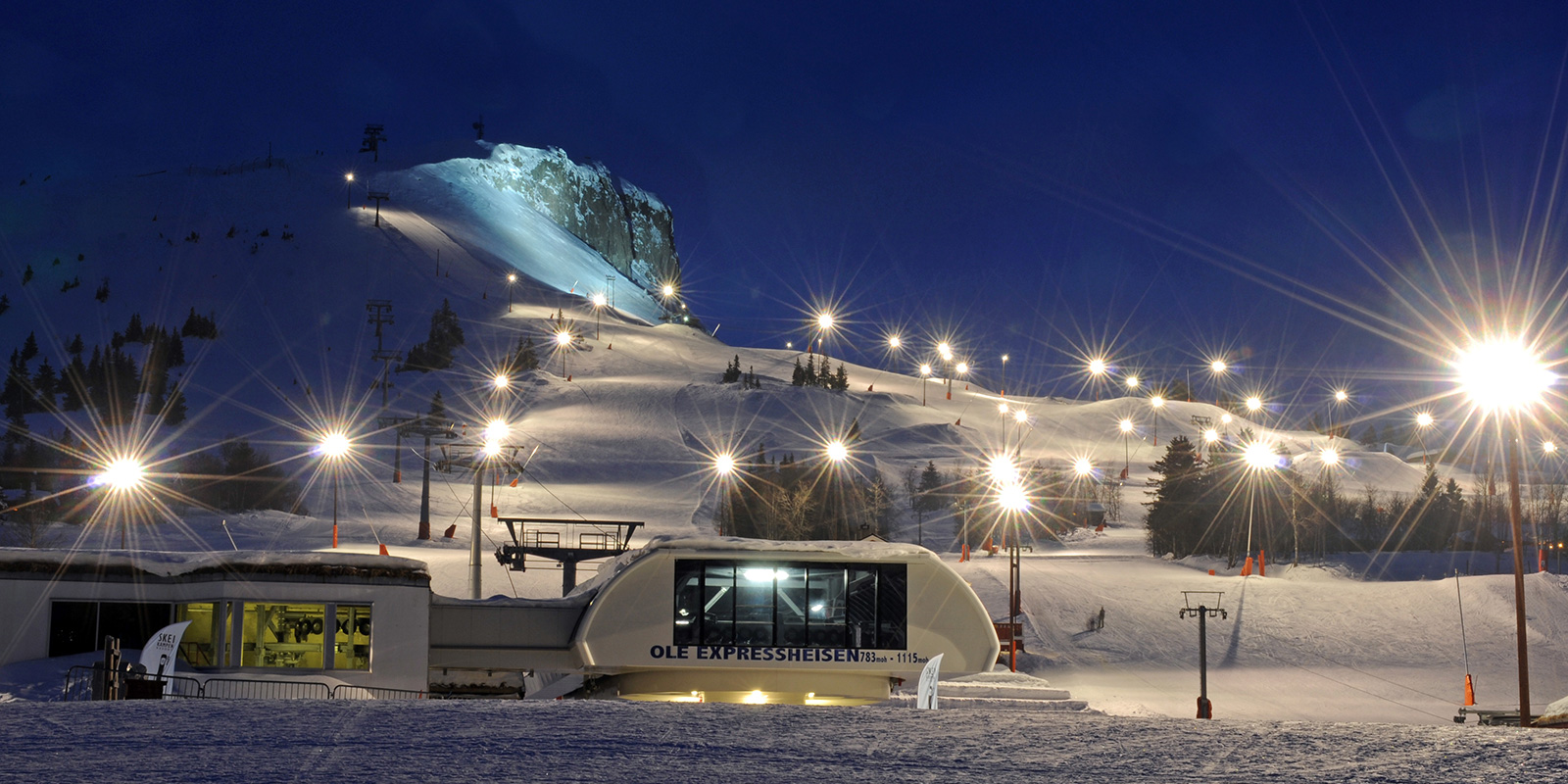 Skibakke opplyst om kvelden med fjellbelysning.