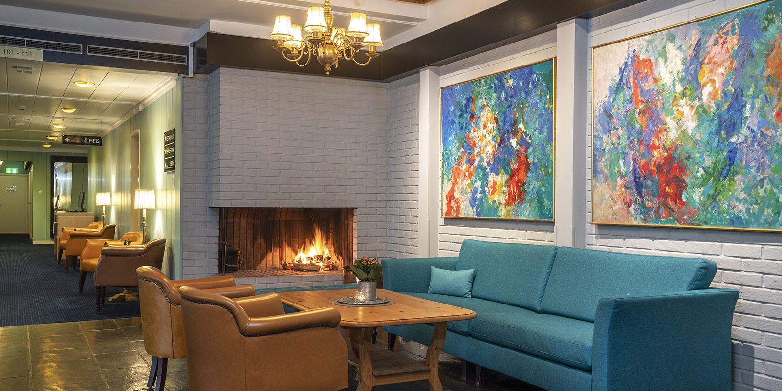 Sofa og sittegruppe foran peisen i lobbyen på Thon Hotel Skeikampen