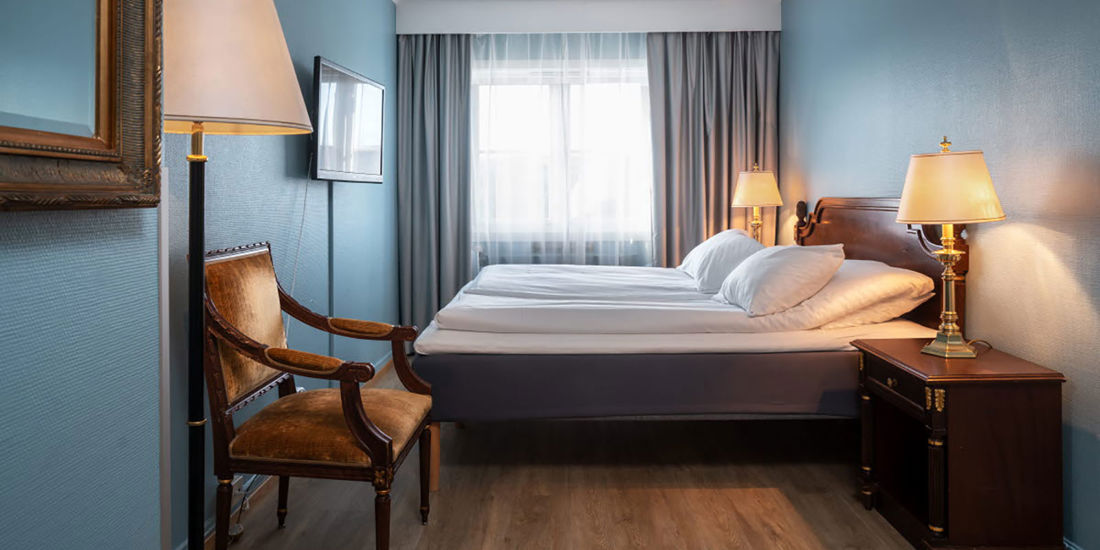 dobbelrom med seng, stol og skrivebord
