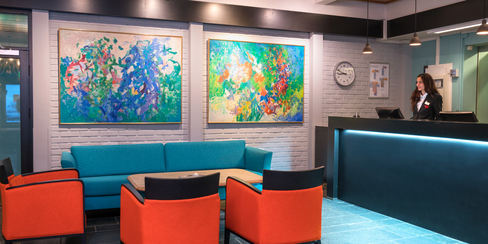 Betjent resepsjon med sofa og sitteplasser og store abstrakte bilder p&#xE5; veggen med dus belysning p&#xE5; Thon Hotel Skeikampen