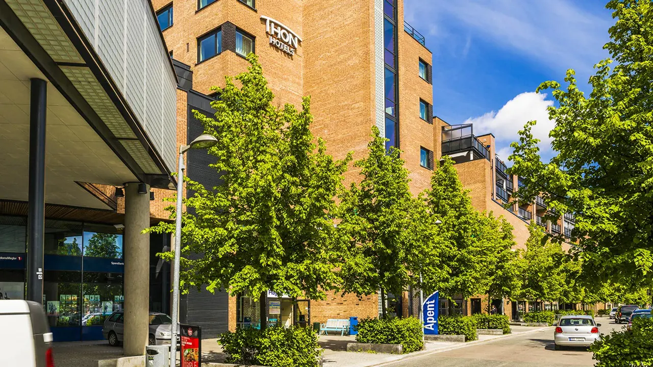 Utsiden av en bygning med trær og biler.